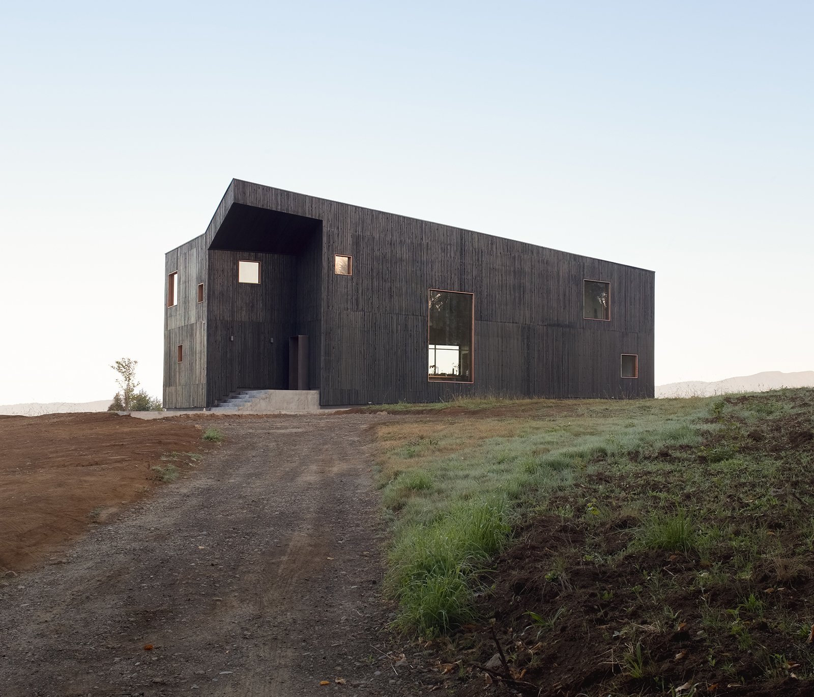 A Black Timber Home in Chile Echoes Local Volcanic Stone