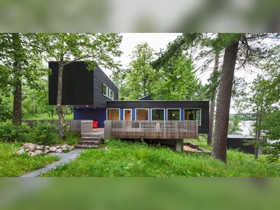 Two Rectangular Volumes Unite to Form a Colorful Lakeside Cabin